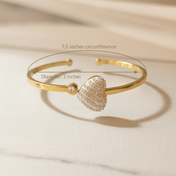 Gold bracelet with heart-shaped clasp on a beige fabric background