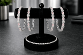 Set of pink beaded bracelets on a black stand with blurred background