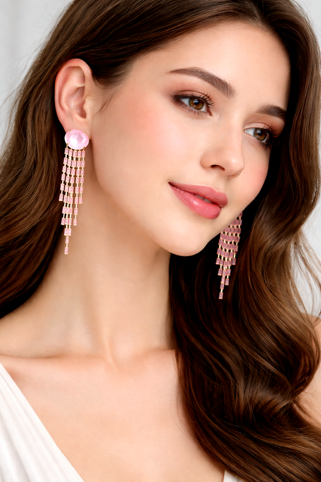 Woman wearing pink earrings with a plain background