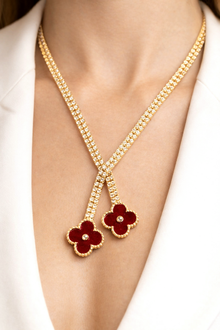 Gold necklace with red flower pendants on a white background