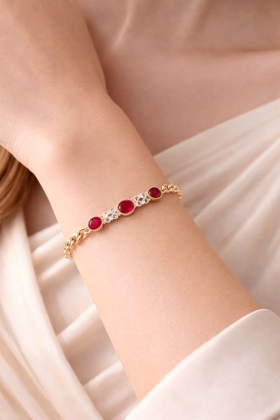 Gold bracelet with red stones on a person&
