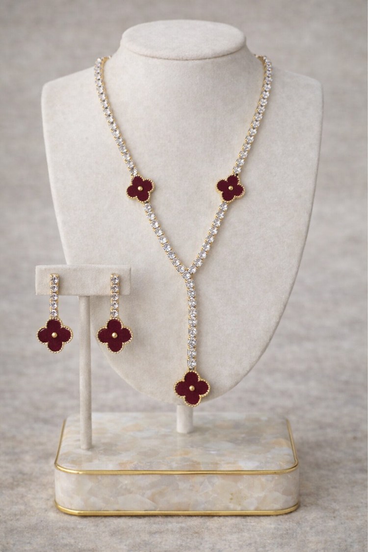 Pearl necklace with red flower pendants on a white mannequin bust against a gray background