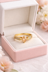 Gold ring with gemstones in a pink jewelry box