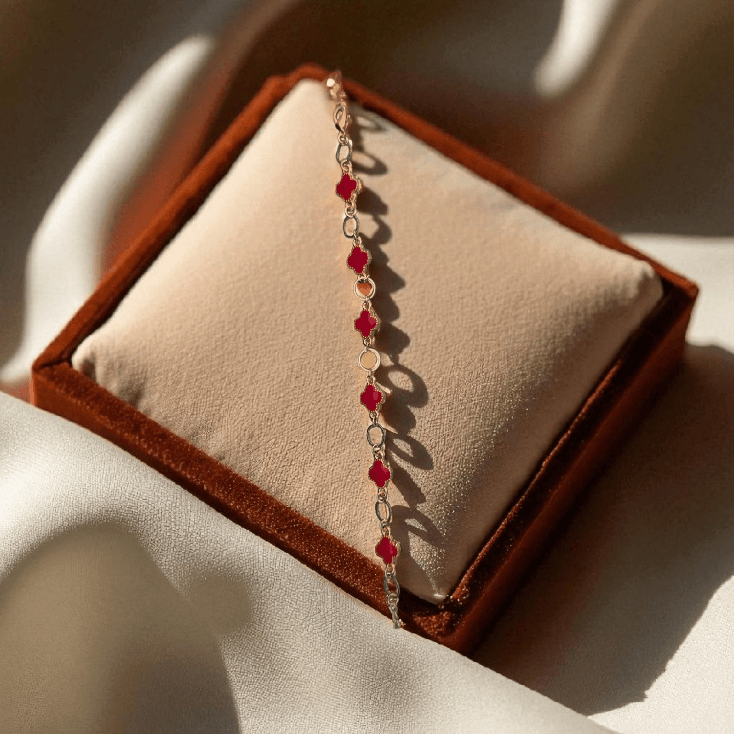 Bracelet with red beads on a brown velvet cushion