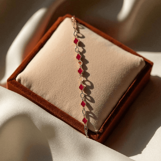 Bracelet with red beads on a brown velvet cushion
