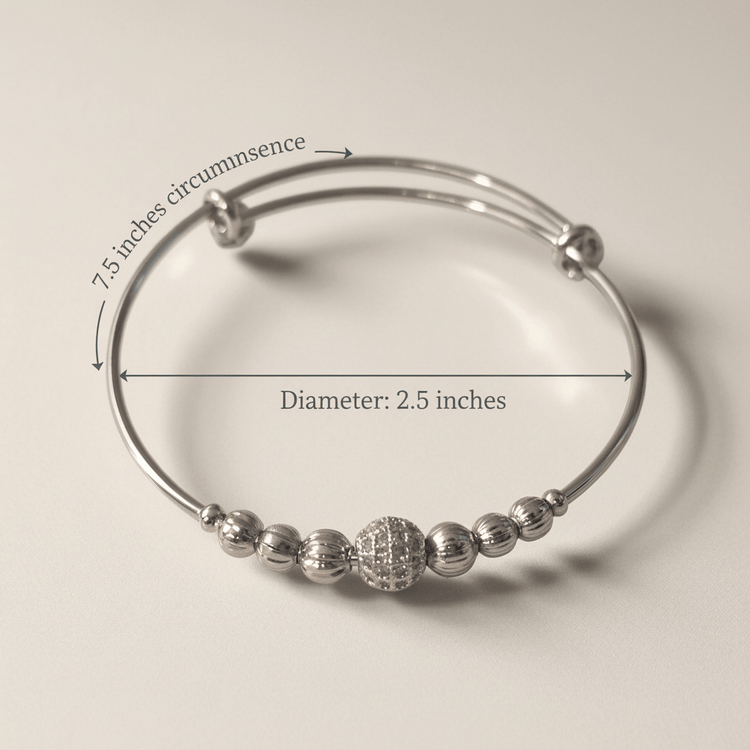 Silver beaded bracelet with measurements on a beige background