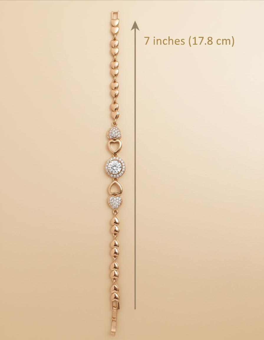 Rose gold bracelet with heart and round charm on a beige background, showing measurement of 7 inches.