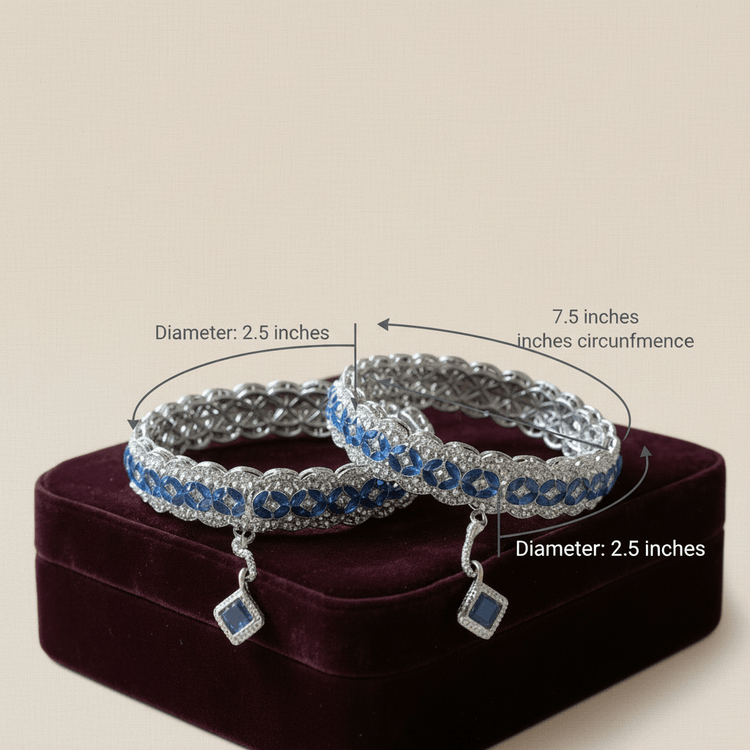 Two silver bracelets with blue stones on a purple stand, showing measurements.