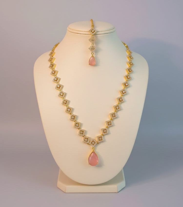 Jewelry set with necklace and earrings featuring pink stones on a light background