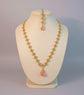 Jewelry set with necklace and earrings featuring pink stones on a light background
