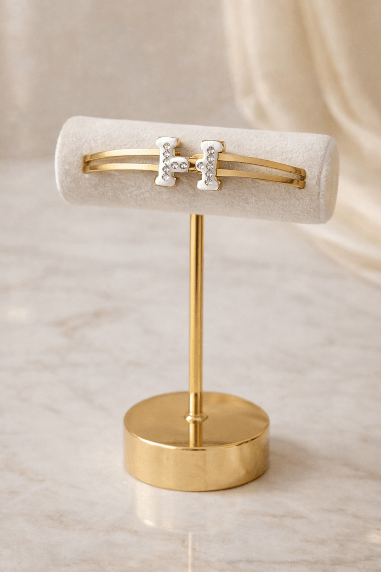 Gold bracelet on a stand with a beige background