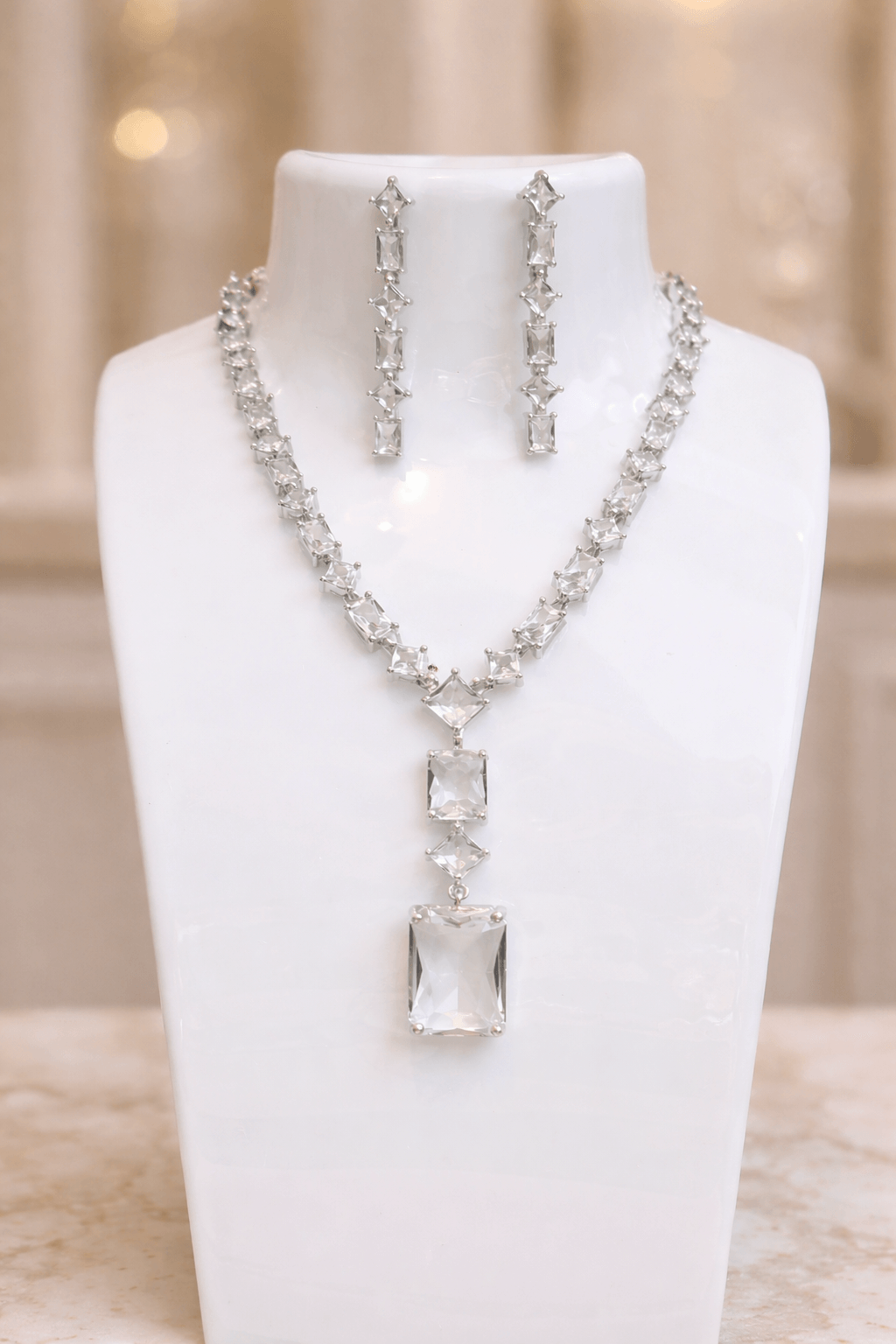 Jewelry set with necklace and earrings on a white mannequin bust.