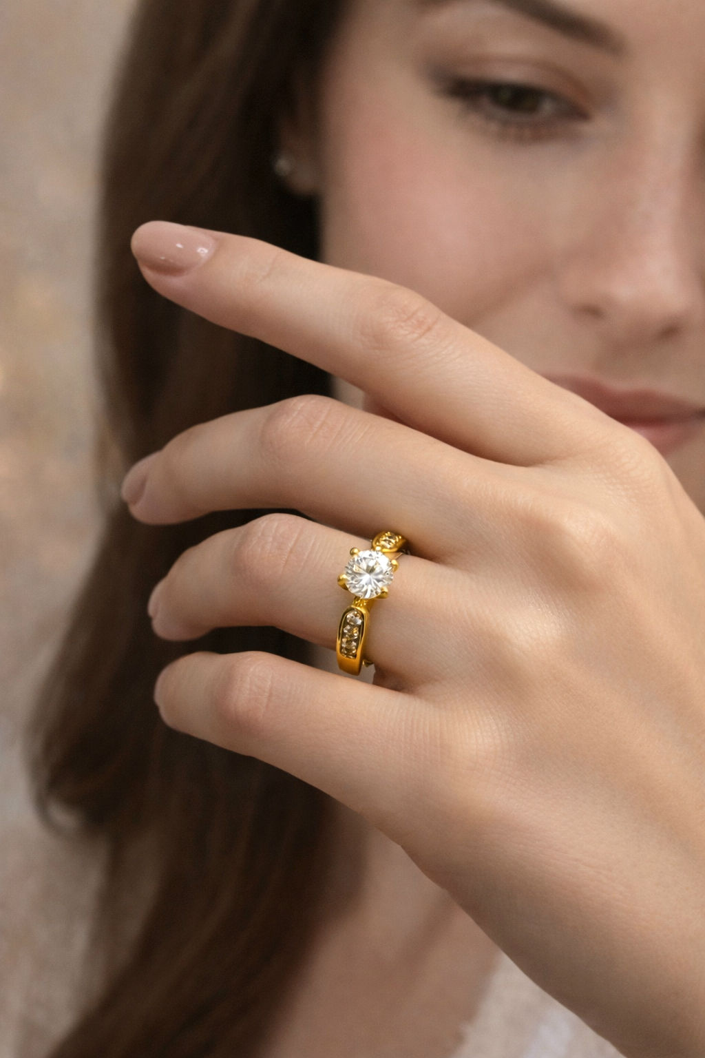 Close-up of a hand wearing a gold ring with a diamond on a blurred background