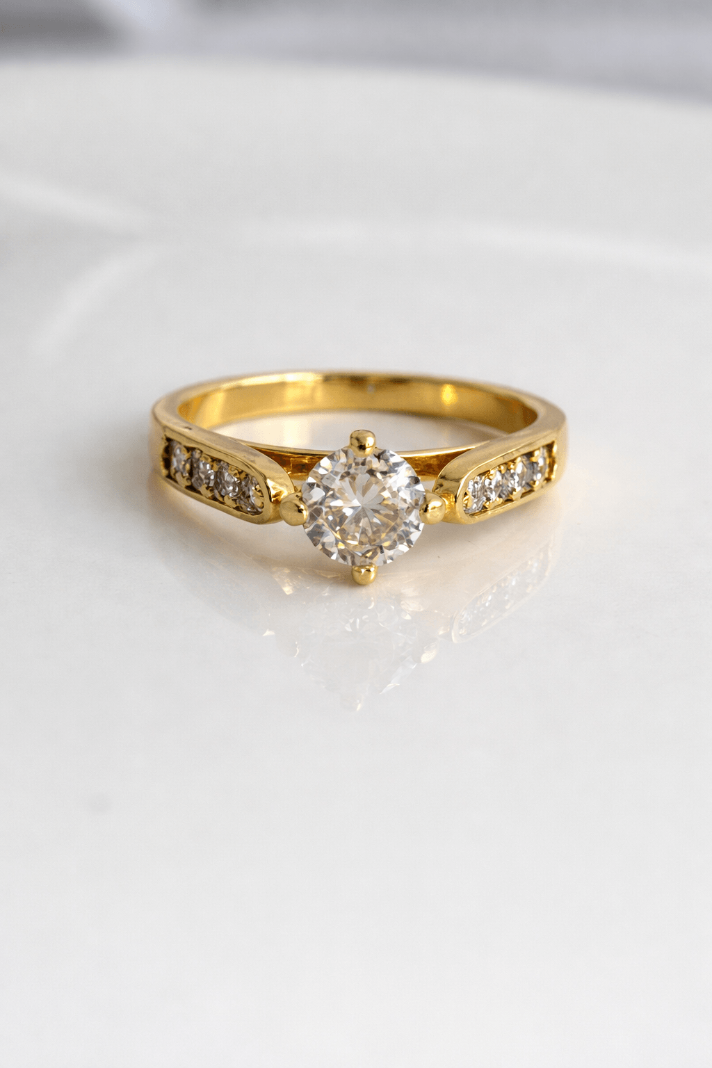 Gold ring with a diamond on a white background