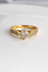 Gold ring with a diamond on a white background
