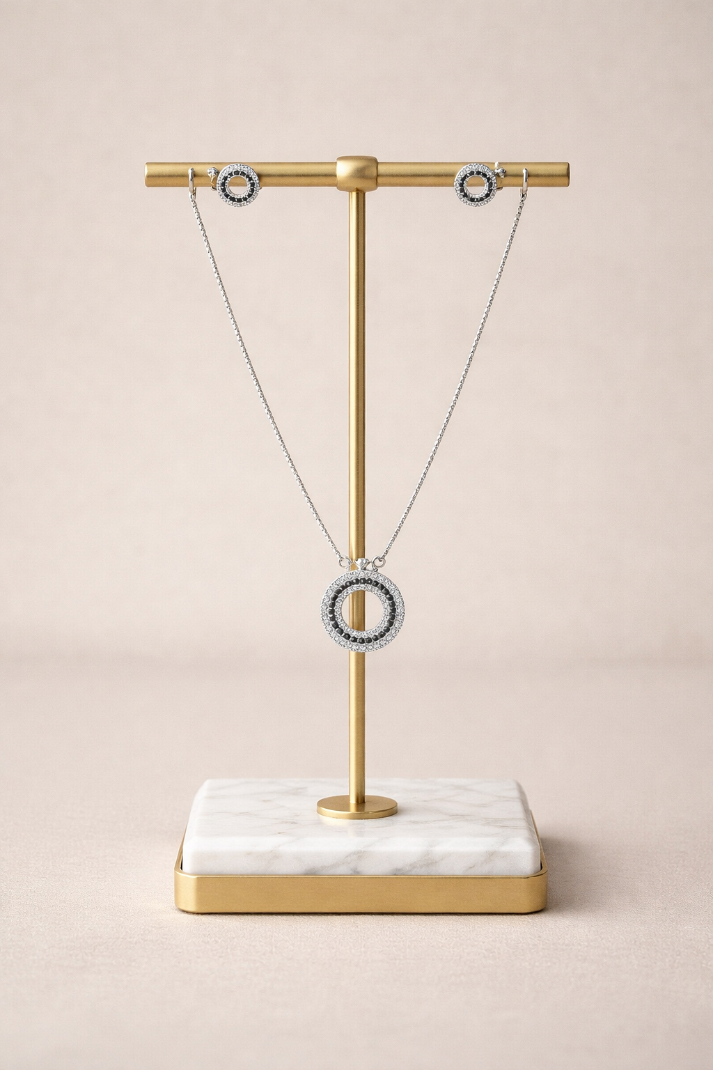 Necklace on a gold and marble stand against a beige background