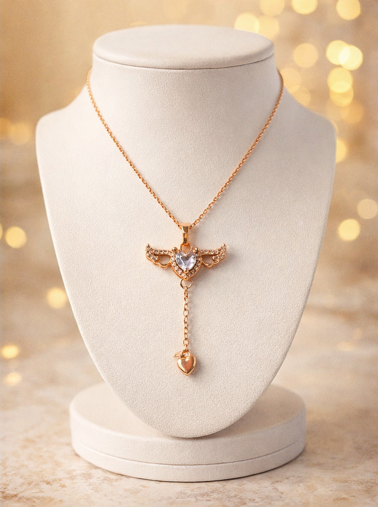 Rose gold necklace with a heart-shaped pendant on a white mannequin bust against a blurred golden light background.