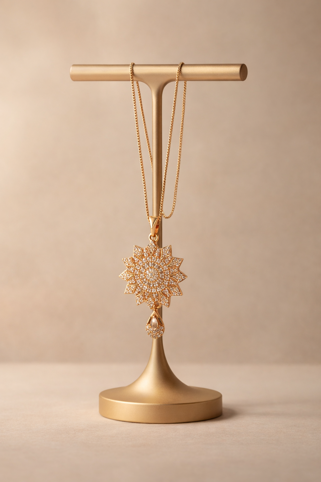 Gold necklace with a star-shaped pendant on a gold stand against a beige background