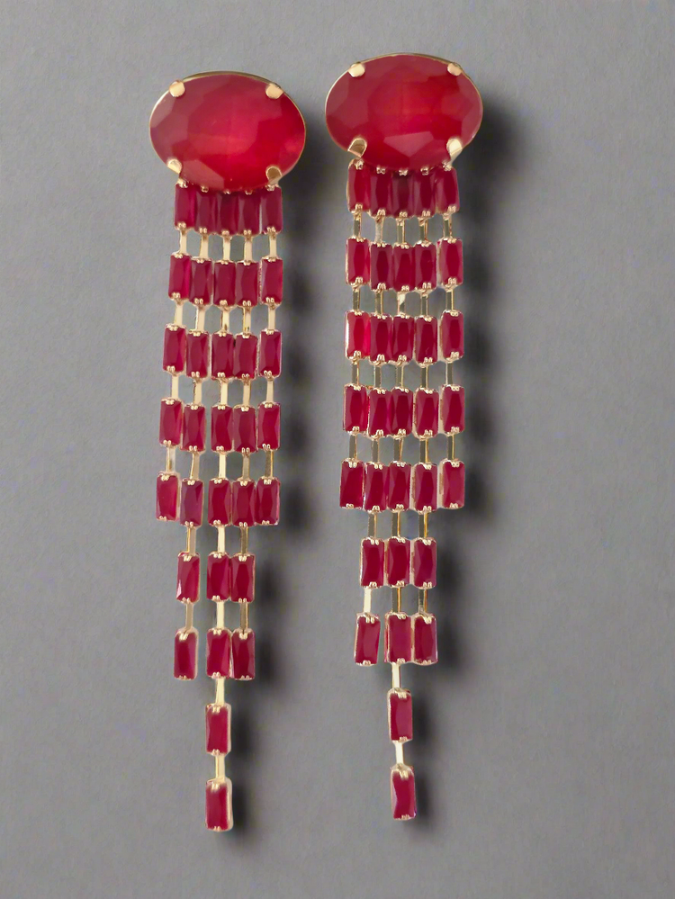Pair of red earrings with gold accents on a gray background
