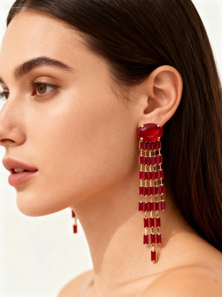 Close-up of a woman wearing red earrings with gold accents on a plain background