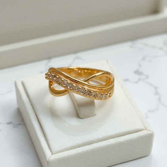 Gold ring with diamond accents on a white jewelry box