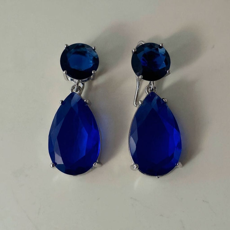 Pair of blue teardrop earrings on a light gray background