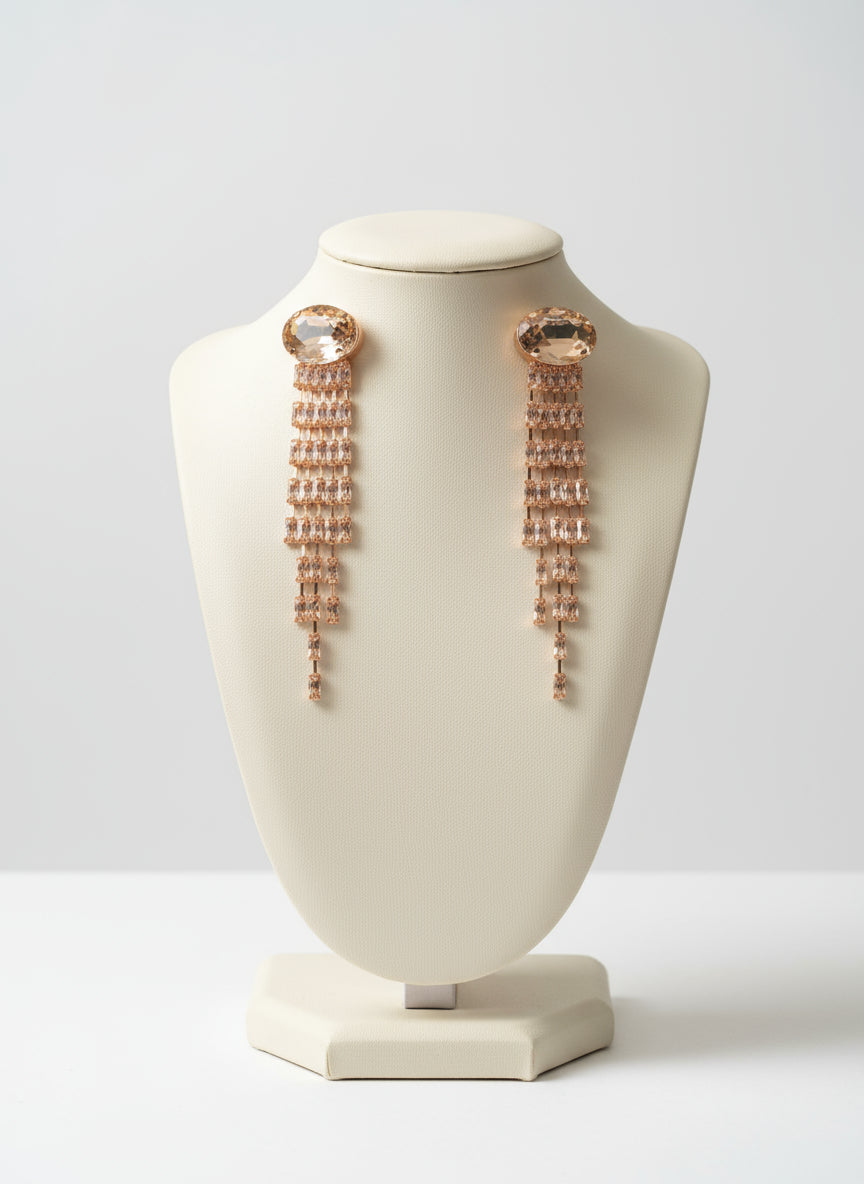 Rose gold earrings on a white bust against a light gray background