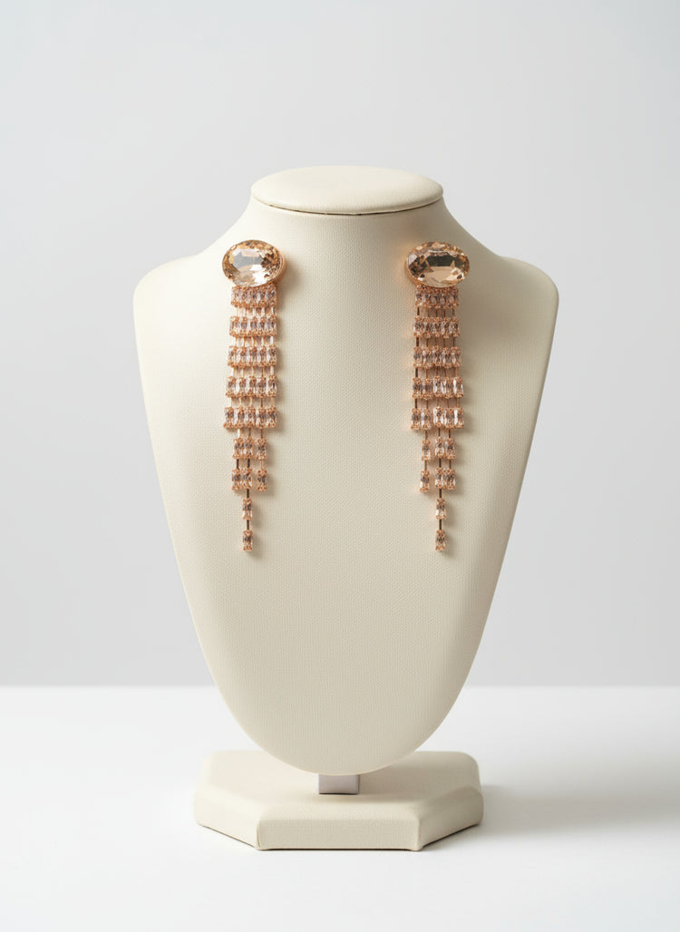Rose gold earrings on a white bust against a light gray background