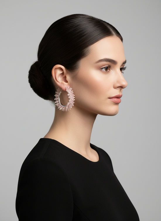 Woman wearing large hoop earrings against a gray background
