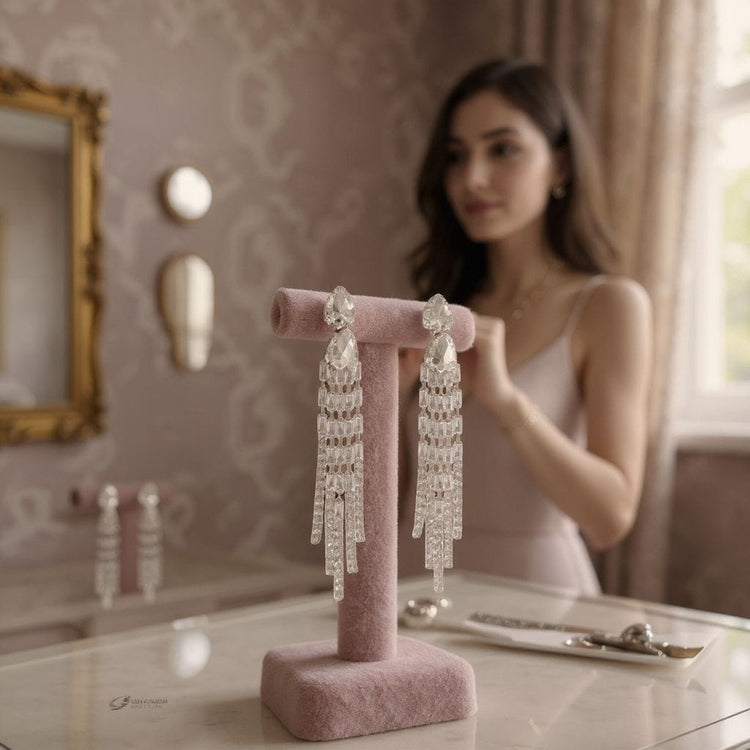 Pink jewelry stand with crystal earrings in a room with decorative elements.