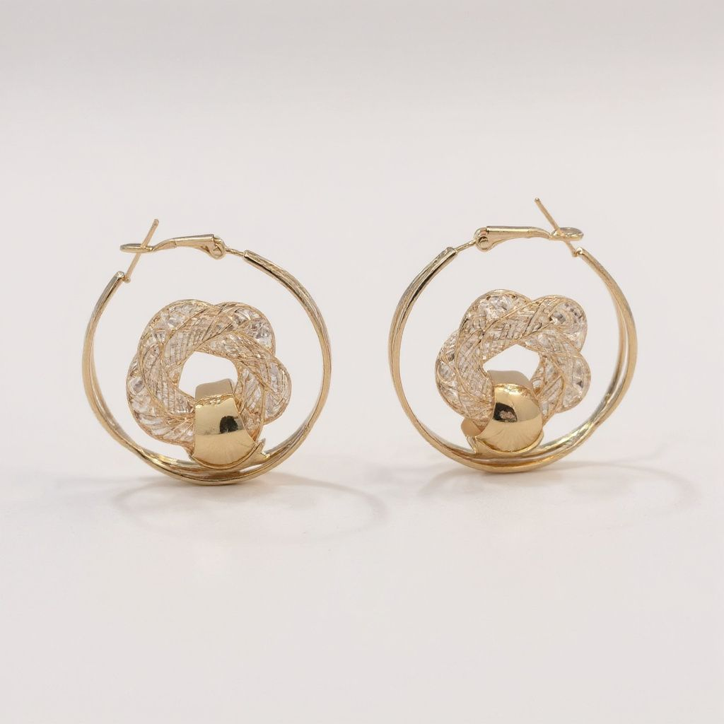 Gold hoop earrings with intricate designs on a light background