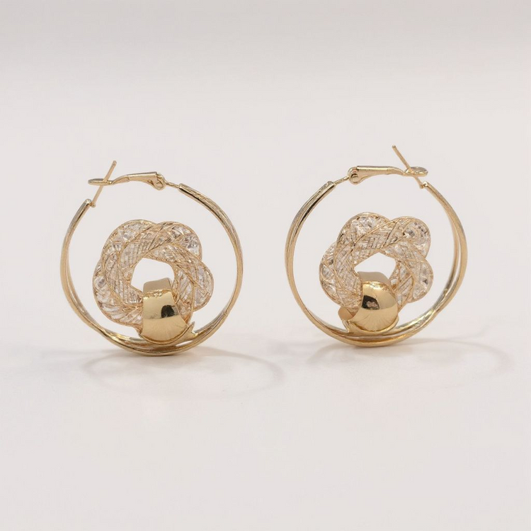 Gold hoop earrings with intricate designs on a light background