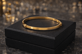 Gold bracelet on a black box with a blurred background